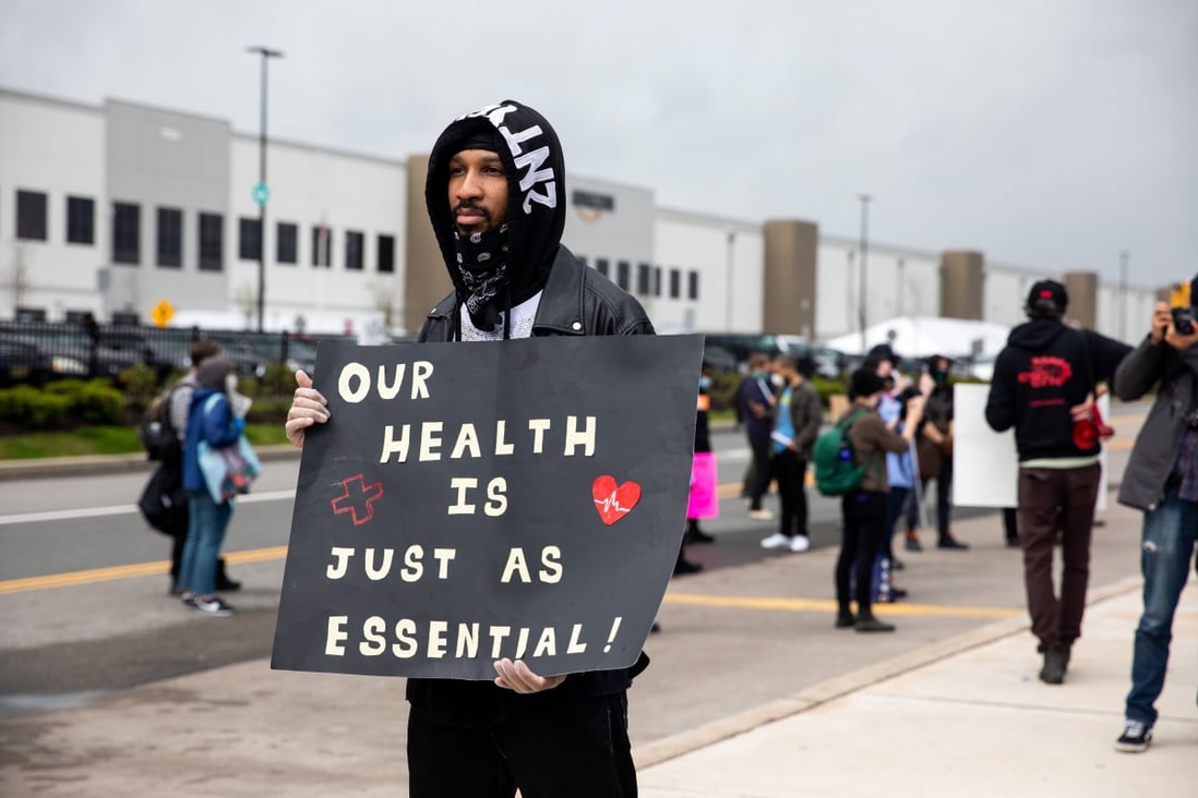 Chris Smalls, a fired Amazon.com fulfilment centre employee, centre, holds a sign during a protest outside the company’s facility in Staten Island, a borough of New York City, on May 1. Photo: Bloomberg
