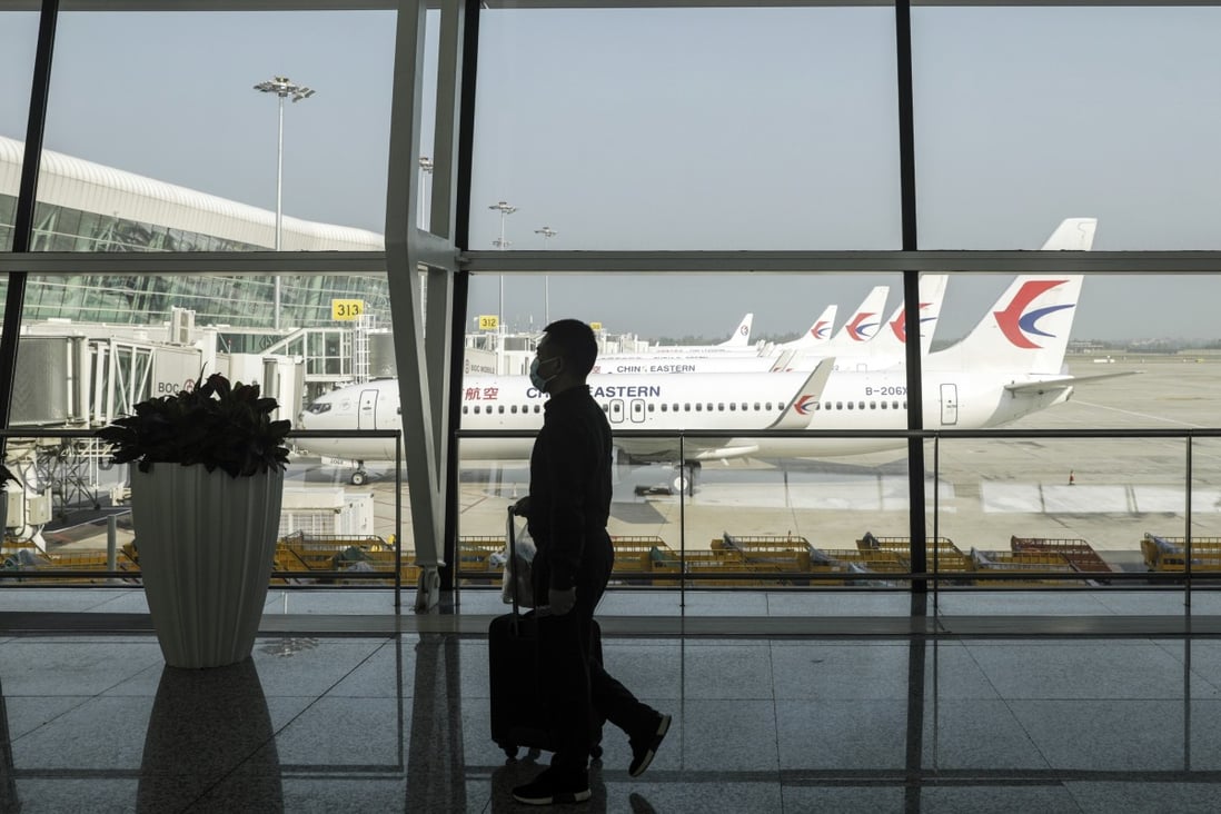 A passenger wearing a protective mask walks past China Eastern Airlines Corp. aircraft standing on the tarmac at the Wuhan Tianhe International Airport in Wuhan, China, on May 2. Photo: Bloomberg