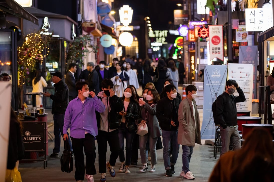 People wearing protective face masks walk through the Itaewon district in Seoul. Photo: Bloomberg