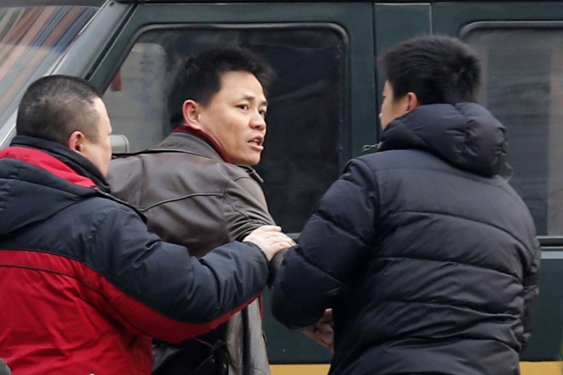 Zhang Xuezhong (centre) pictured in 2014 during an encounter with plain-clothes police officers. Photo: Reuters
