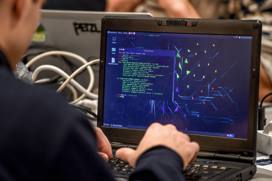 A man delivers a computer payload while working on a laptop on January 22, 2019 in Lille, during the 11th International Cybersecurity Forum. Photo: AFP