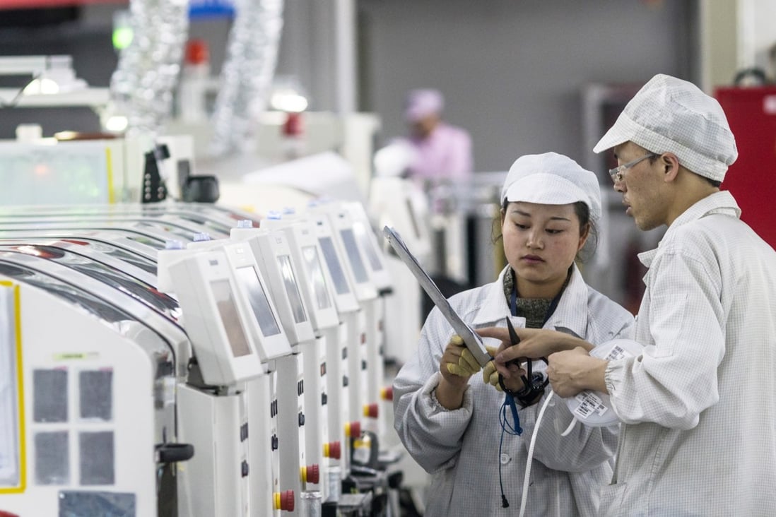 File photo of people working on machines at the Foxconn factory in Guiyang, China. Foxconn produces electronic devices for Apple and other leading IT companies. Photo: EPA-EFE