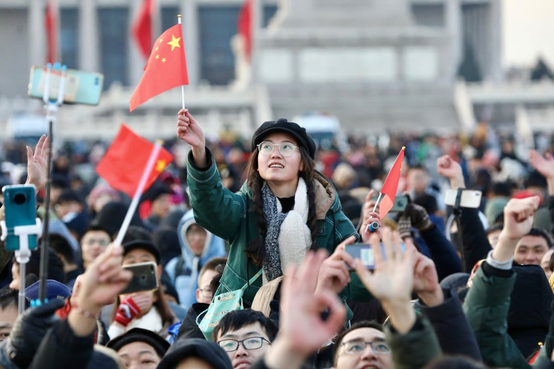 People wave Chinese flags as they gather for a flag-raising ceremony to mark the New Year in Tiananmen Square in Beijing. Photo: Reuters
