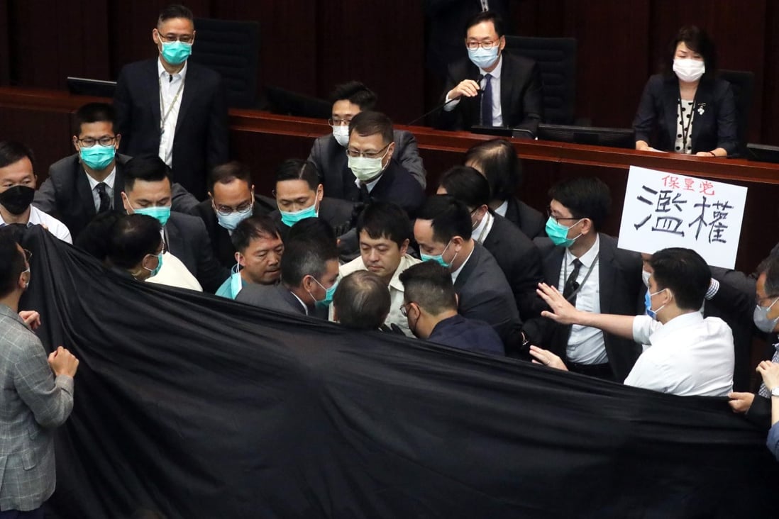 Opposition lawmakers and security guards clash in front of House Committee chairman Chan Kin-por. Photo: Dickson Lee