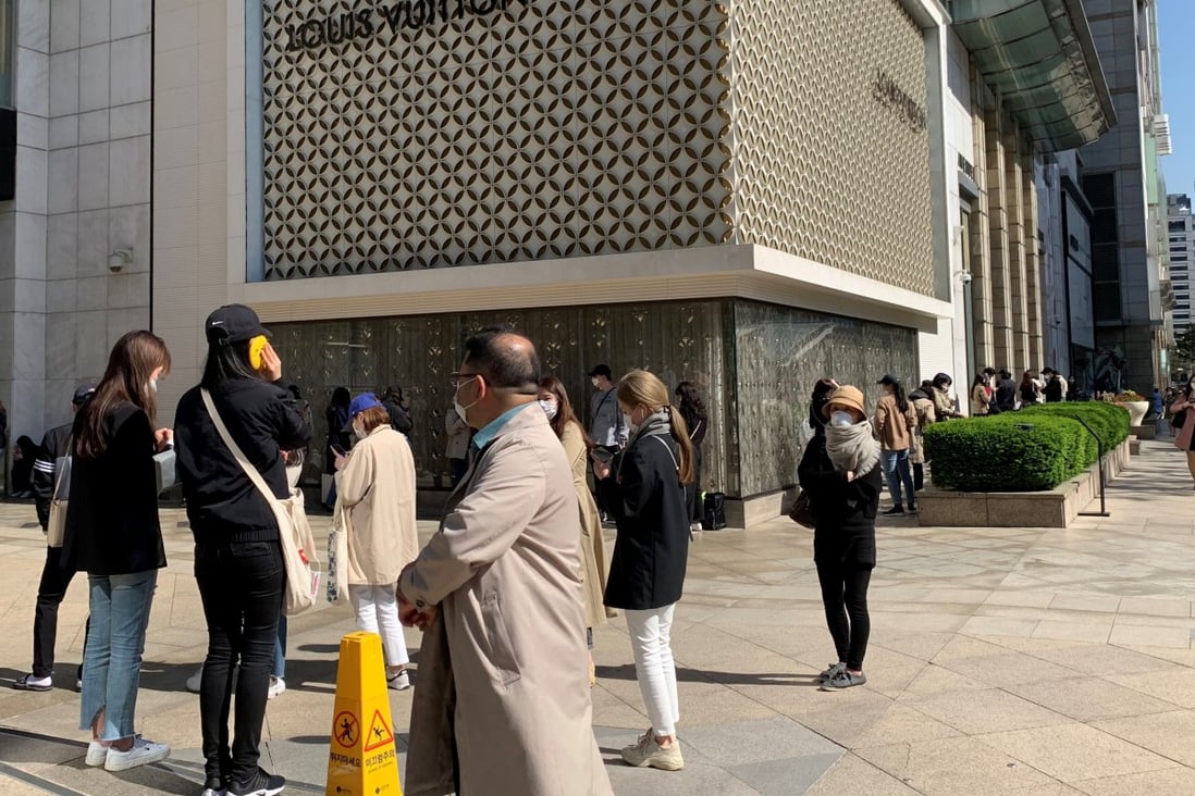 People practise social distancing as they queue to enter the Chanel boutique at a department store in Seoul on Wednesday ahead of price rises on some bags and leather goods. Photo: Reuters