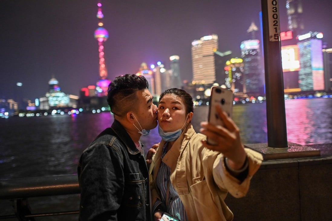 A couple wearing face masks visit the promenade on the Bund along the Huangpu River during a holiday on May Day on May 1, 2020. Photo: AFP