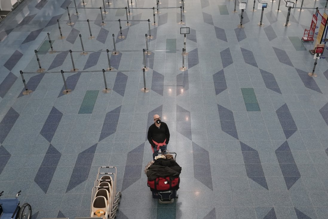 A man wearing a mask stands alone at the departure counter at Tokyo International Airport at Haneda in Tokyo on March 6. There is an urgent need to begin laying the ground rules on resumption of travel, and the first step is likely to be the creation of “travel bubbles”. Photo: EPA-EFE
