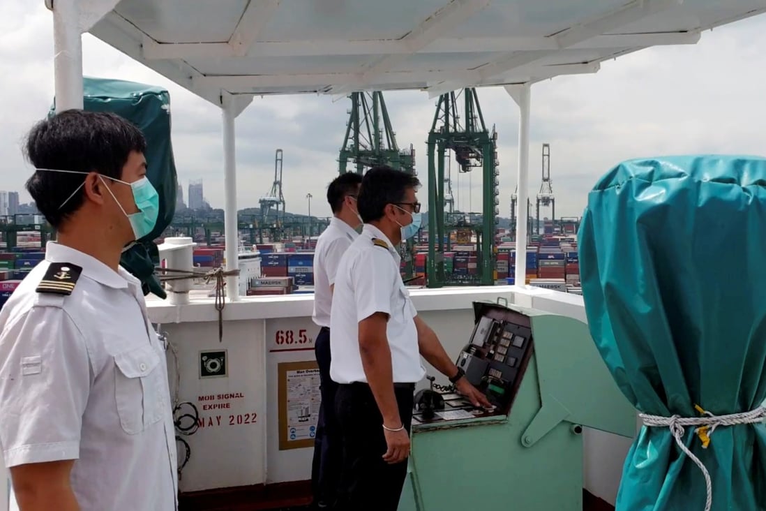 A crew member wearing a protective face mask sounds the horn of their boat, as all working ships sound their horns at the port of Singapore at noon on May 1, in a show of support for seafarers who have helped to keep supply chains open and facilitate maritime trade amid the Covid-19 outbreak. Photo: Handout via Reuters