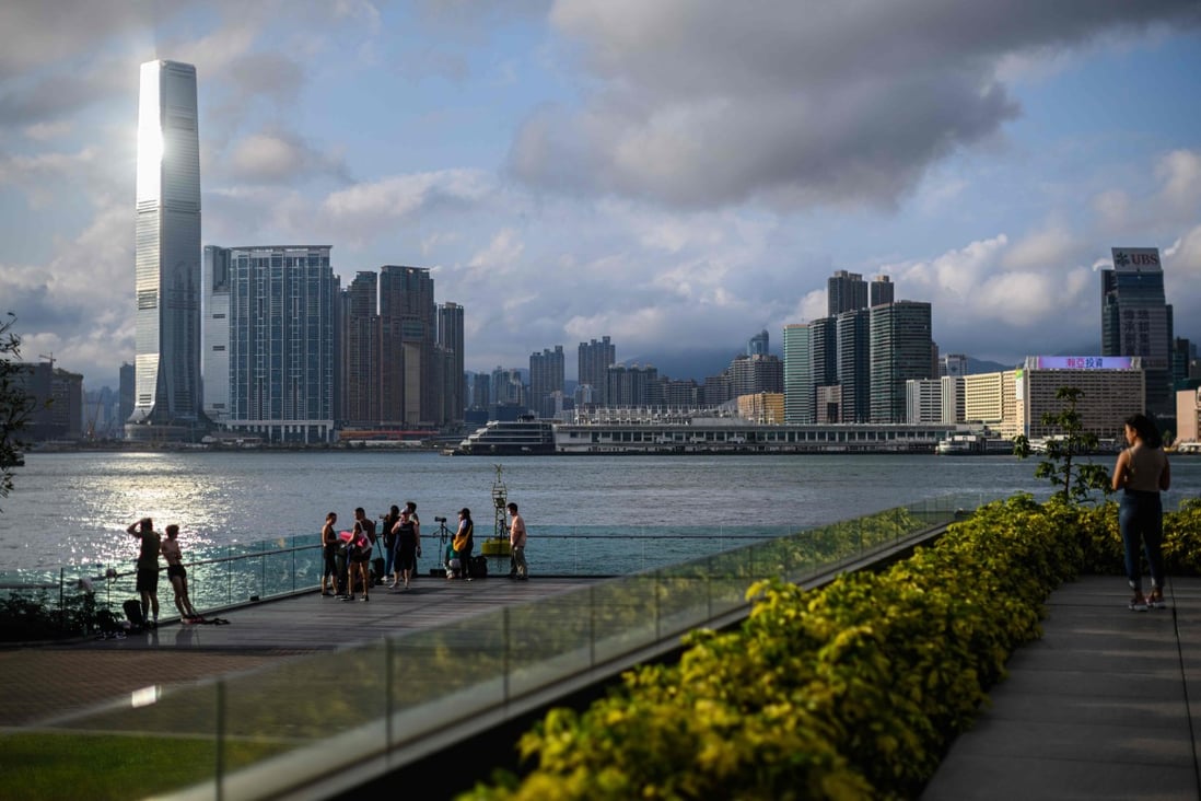 People gather at Tamar Park, overlooking Hong Kong’s Victoria Harbour, to watch the sunset. For some people weighing the pros and cons of staying in Hong Kong, in the wake of the city’s political protests and the coronavirus outbreak, Singapore may seem a safe haven. Photo: AFP