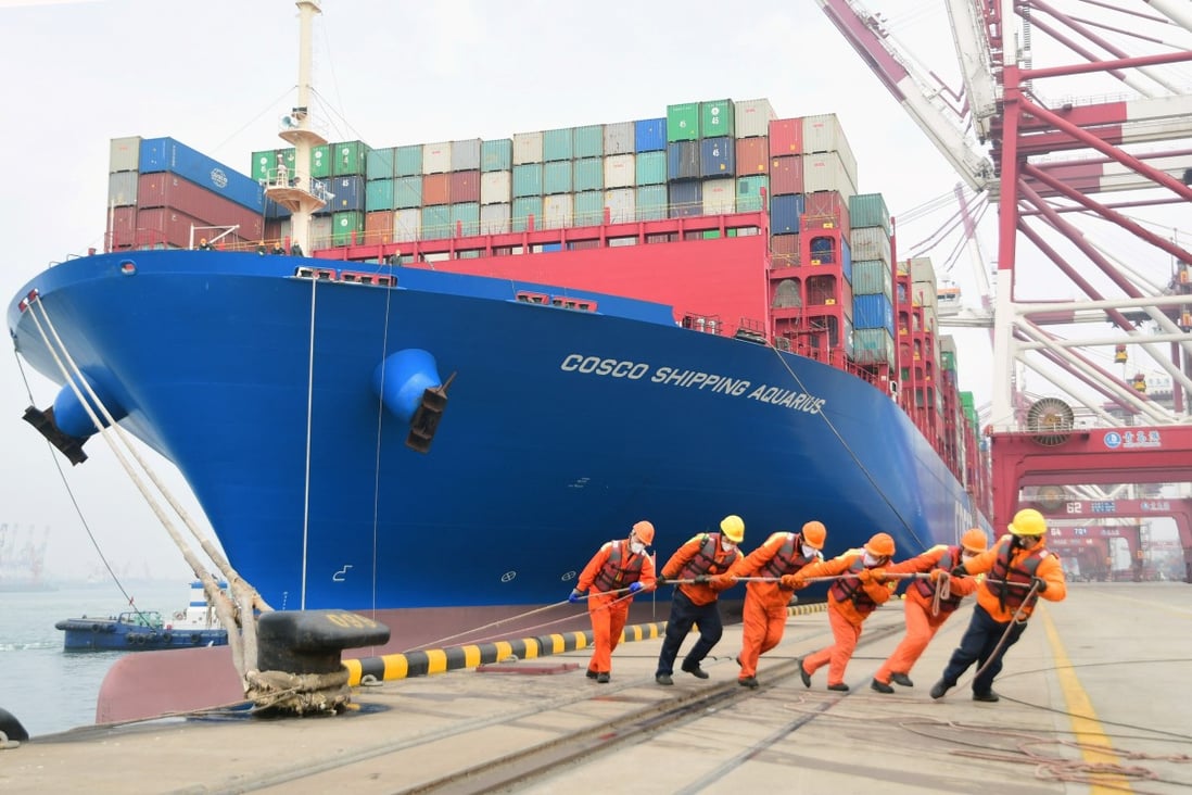 Workers wearing face masks rope a container ship at a port in Qingdao, Shandong province, China, on February 11. Global trade declined by 3 per cent in value during the first quarter of this year. Photo: China Daily via Reuters