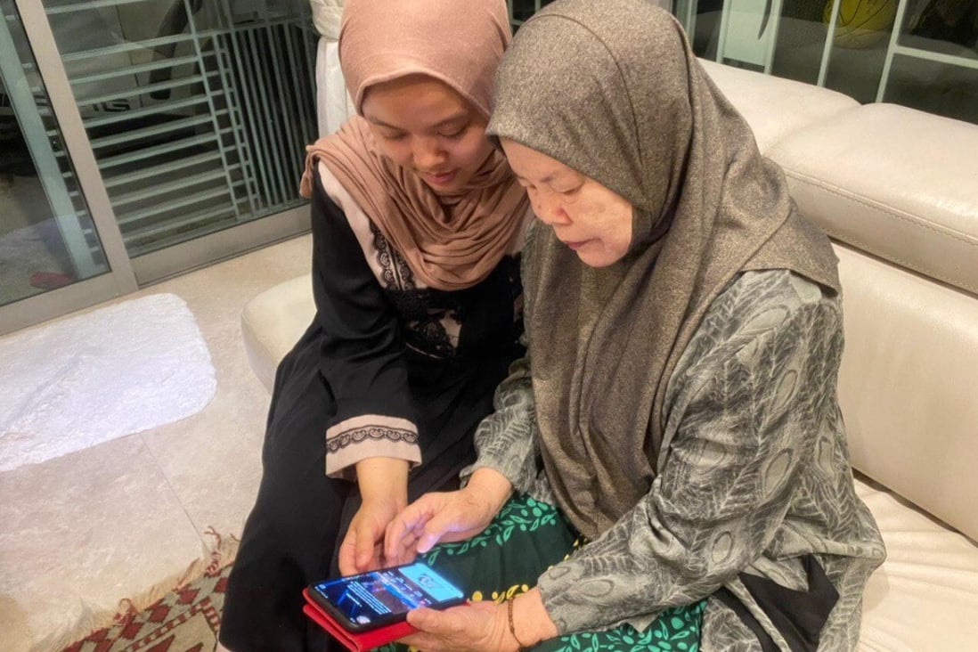 Aisya Amira Abam Malik teaches her grandmother how to use internet banking applications to send virtual green packets during Hari Raya. Many of Singapore’s elderly citizens who are not digitally savvy have felt cut off during the Covid-19 restrictions. Photo: Kimberly Lim