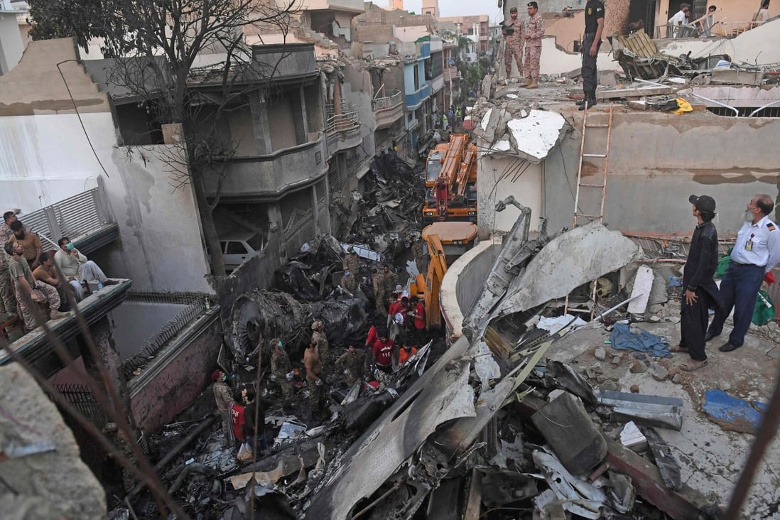 Security personnel search for victims in the wreckage of a Pakistan International Airlines aircraft after it crashed in a residential area in Karachi on May 22. Photo: AFP