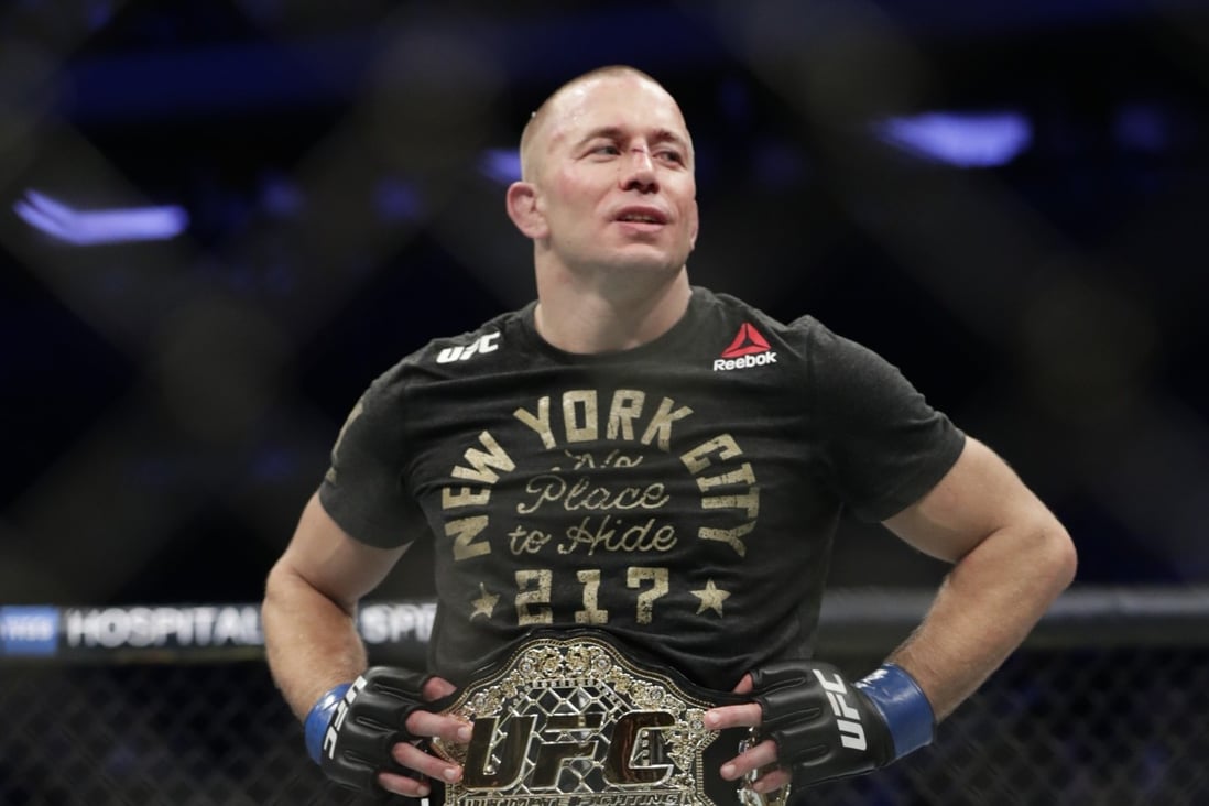Georges St-Pierre celebrates his middleweight title win against Michael Bisping at UFC 217. Photo: AP