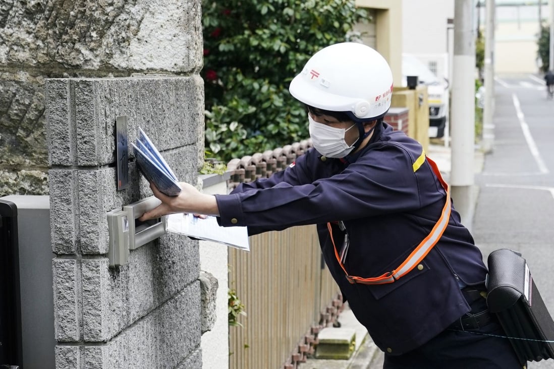 A mail carrier delivers cloth masks in Tokyo in April, during a coronavirus outbreak in Japan. Photo: Kyodo