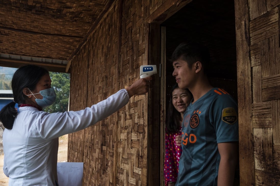 Volunteers conduct a daily temperature screening of those in quarantine at Je Yang internally displaced person camp near Laiza, Myanmar. The camp, with a population of 8,700, is the largest of Kachin’s IDP camps. Photo: Ring Nu Awng