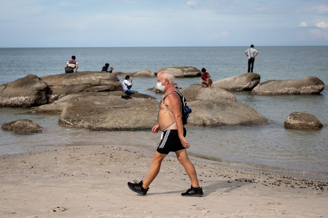 A visitor to a beach Thailand wears a face mask. The country is promoting itself as a clean, safe destination for when tourism restarts. Photo: Jack Taylor/AFP via Getty Images