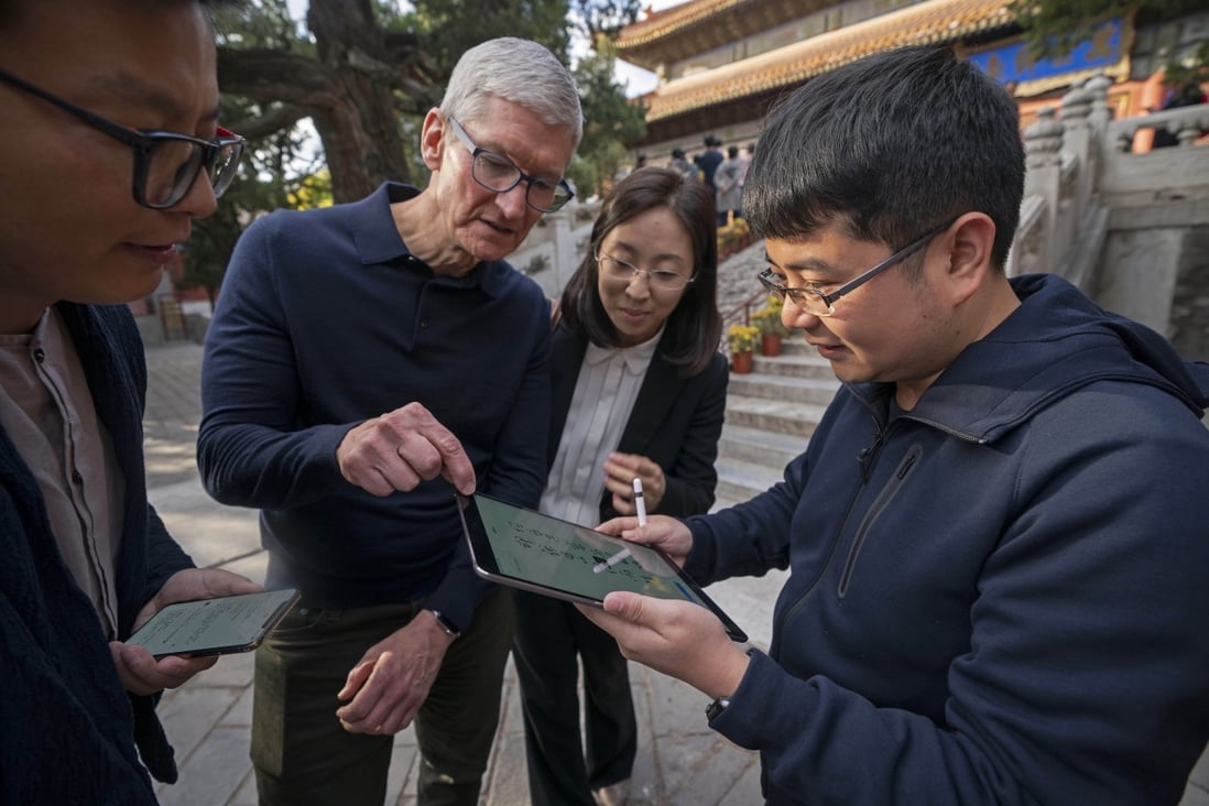 Apple CEO Tim Cook (centre, left) is shown how to write calligraphy on an iPad in this file photo taken in Beijing, Oct. 10, 2018. Apple lost its No 1 position in China’s tablet market in the first quarter. Photo: Xinhua