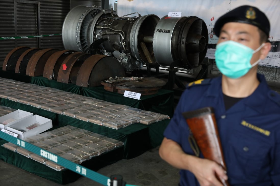 A customs officer stands guard in front of the cocaine worth HK$246 million (US$31.7 million) hidden in an aircraft engine. Photo: Nora Tam
