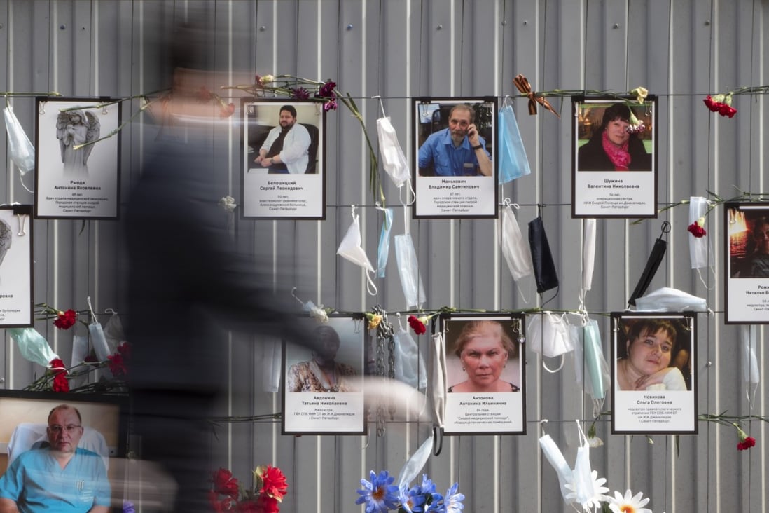Medical face masks and portraits of medical workers who died from coronavirus infection, hang at a unofficial memorial in St Petersburg, Russia. Photo: AP