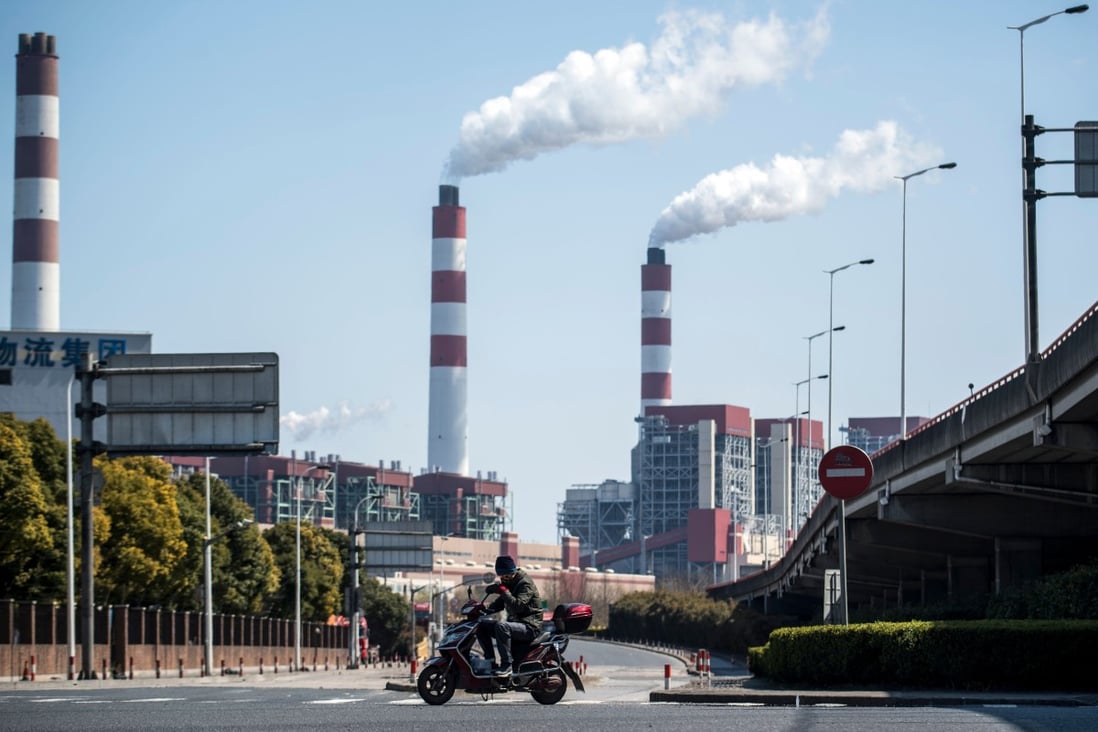 A man rides his scooter near a coal power plant in Shanghai. File photo: AFP