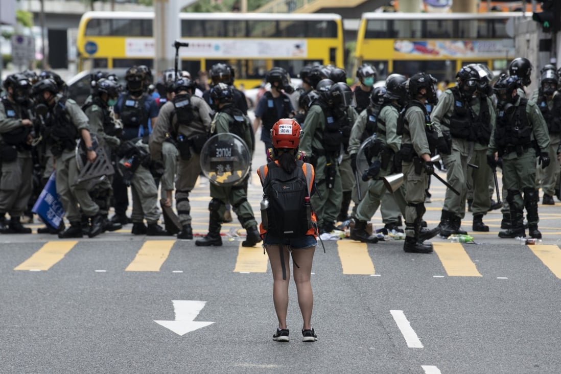 A woman stands in front of police during a protest against Beijing's move to enact a new national security law for Hong Kong, in Causeway Bay on May 24. Photo: DPA