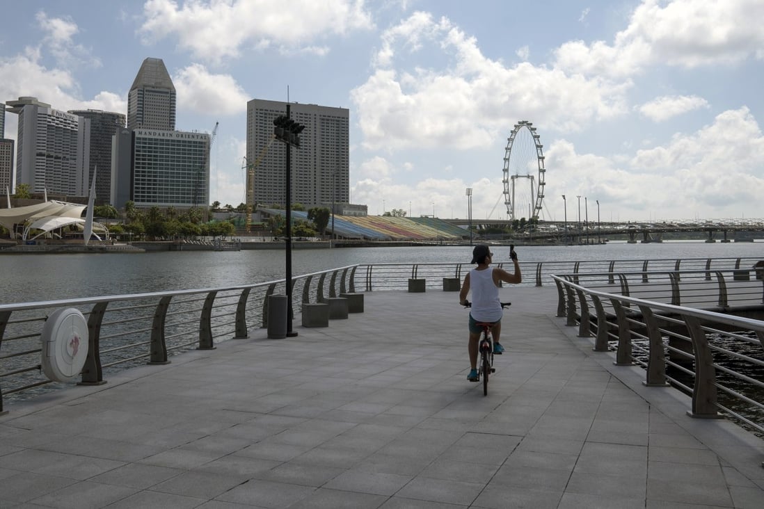 A cyclist rides along the pier at the near-empty Merlion Park in Singapore. Photo: Bloomberg