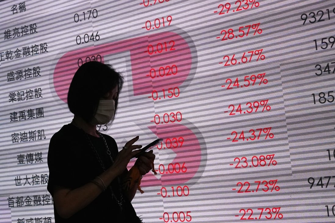People walk past an electronic board showing the falling Hang Seng Index in Central, Hong Kong. Traders are tormented on market direction as Beijing endorses a resolution for a security law for the former British colony. Photo: Felix Wong