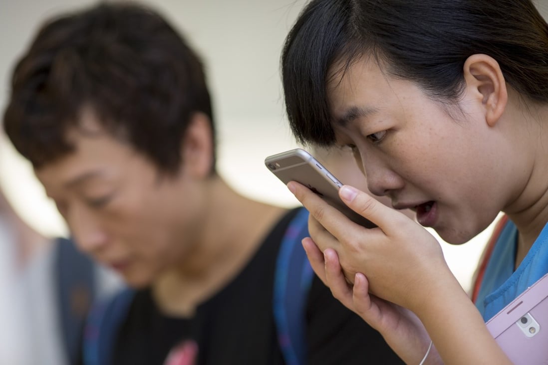 A customer uses the Siri voice-activated digital assistant on an iPhone at an Apple Store in Hong Kong. Apple has been buying up a number of tech start-ups to boost the functionality of Siri on its various devices. Photo: Bloomberg