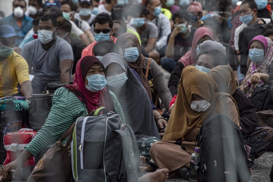 Undocumented migrants sit during a raid in Petaling Jaya near Kuala Lumpur on May 20, 2020. Photo: EPA-EFE