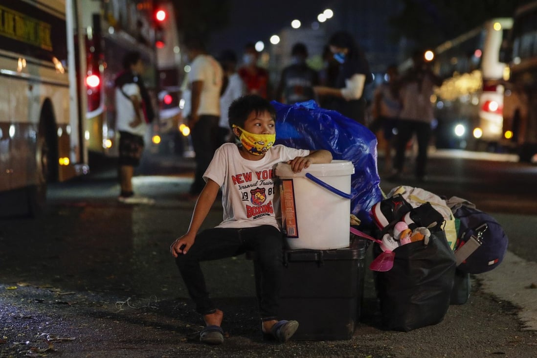 A boy waits for a bus put on to ferry away those stranded in the Philippine capital amid the almost three-month coronavirus lockdown. Photo: AP