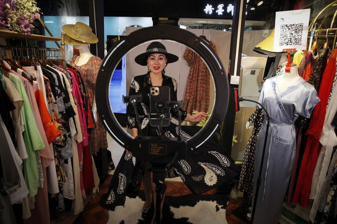 Song Huiyan shows fashion dresses to online clients during a live-streaming event at her clothing shop in Beijing in April. Photo: AP