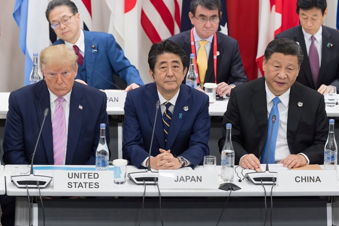 Japan’s Prime Minister Shinzo Abe between US President Donald Trump and China’s President Xi Jinping. Photo: AFP