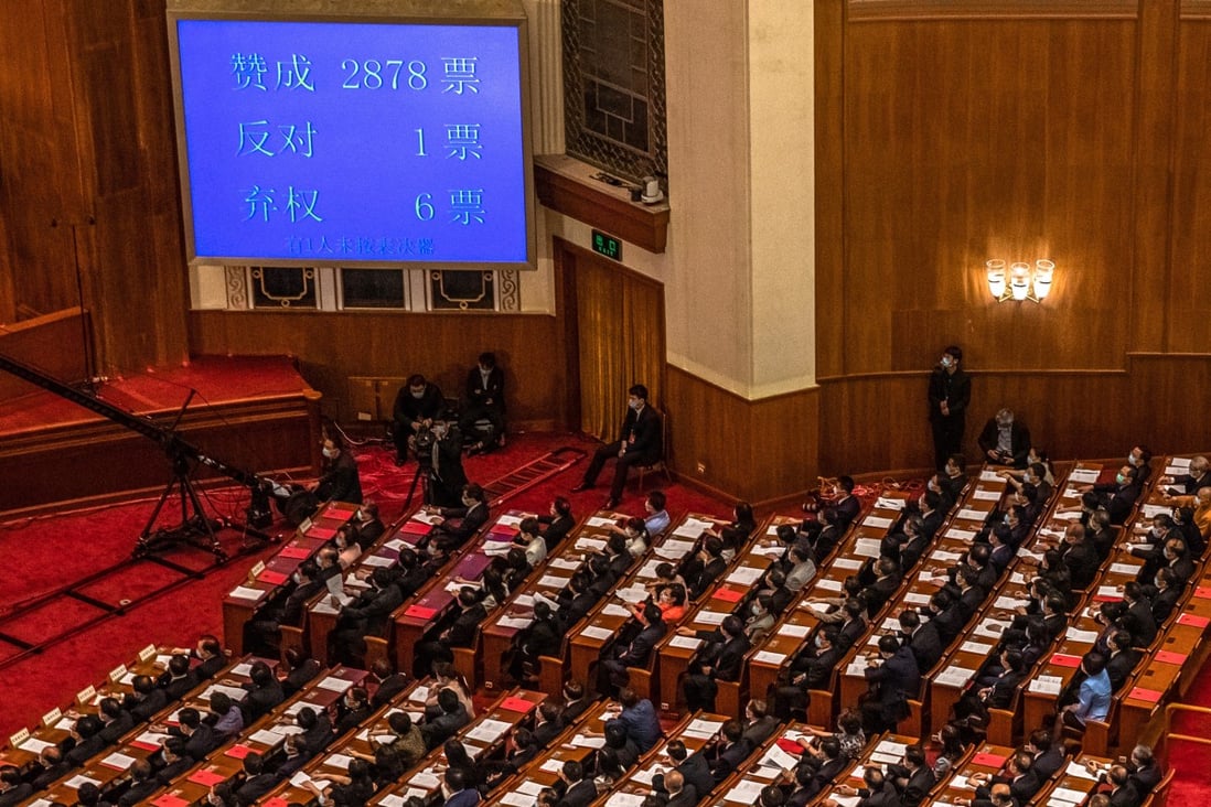 Delegates applaud as the result of a vote on the draft resolution for a controversial national security law for Hong Kong is displayed on a screen during the closing ceremony of the third session of the 13th National People’s Congress, at the Great Hall of the People in Beijing on May 28. Photo: EPA-EFE