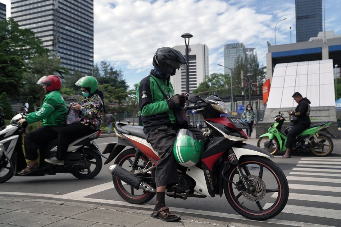 Gojek drivers sit on their motorcycles along a street in Jakarta, Indonesia, on Wednesday, April 1, 2020. Photo: Bloomberg