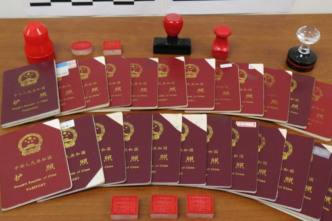 Chinese passports and stamps seized by Canadian border agents as part of an investigation into an immigration fraud scheme in Vancouver in 2015. Photo: Canada Border Services Agency