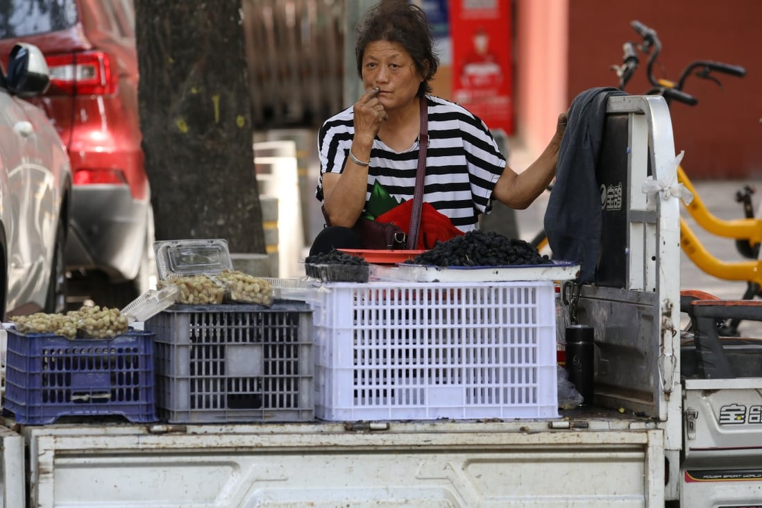 A woman waits for customers to buy mulberries at her mobile stall, a mini truck, in a street in Beijing, China, on June 2, 2020. Photo: SCMP/Simon Song