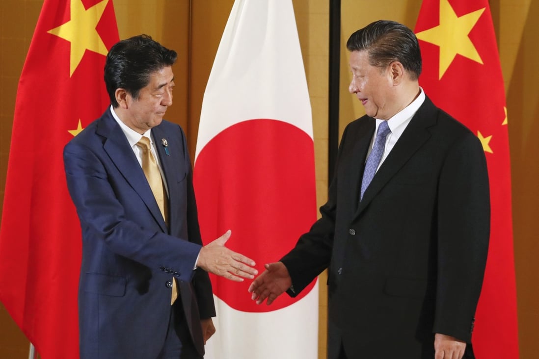 Chinese President Xi Jinping (right) and Japanese Prime Minister Shinzo Abe shake hands at the start of their talks in Osaka in June 2019. Photo: EPA-EFE