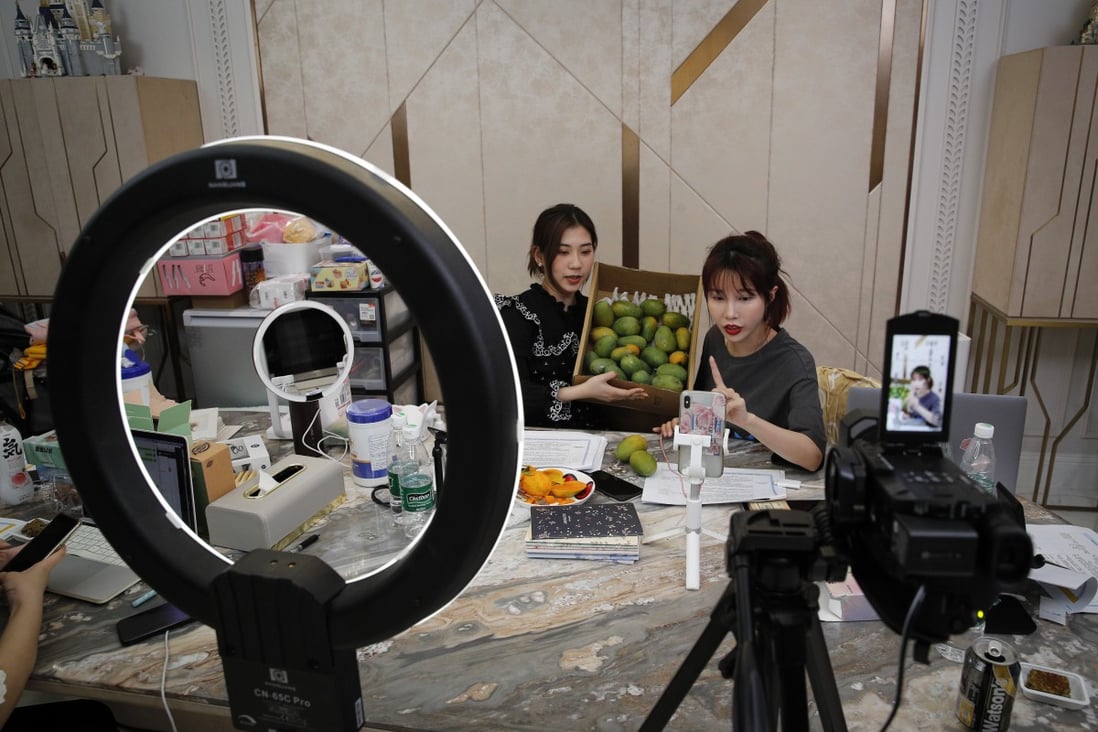 In this May 5, 2020, photo, China's online celebrity Zhang Mofan, right, introduces fresh mangos to her online clients and fans through live-streaming at her house in Beijing. Retailers in China are embracing livestreaming as a sales channel amid a Chinese ‘shoppertainment’ boom accelerated during the Covid-19 pandemic. Photo: AP