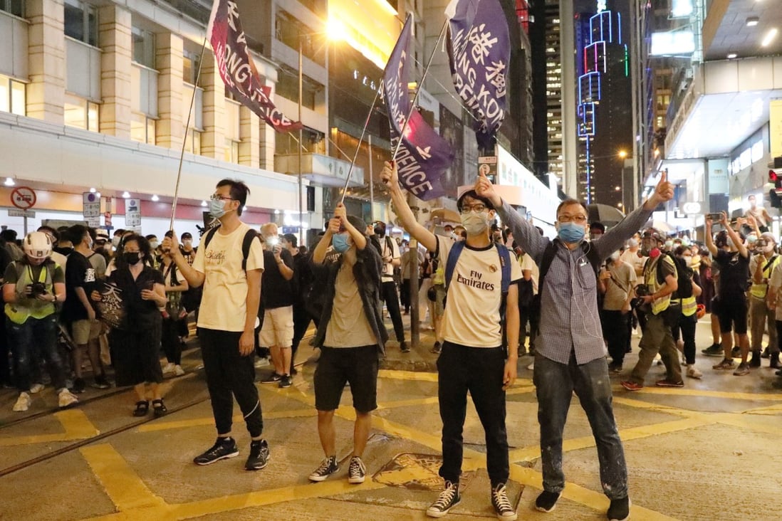 Hong Kong protesters raise their flags and mobile phone flashlights to mark the first anniversary of major anti-extradition bill protests, in Central on June 9. Photo: Dickson Lee