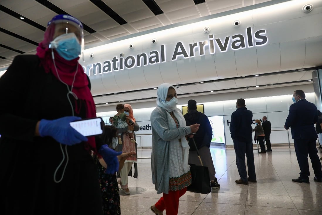 Passengers wearing protective face masks walk through the international arrivals hall of London’s Heathrow Airport in London on June 8, when the UK began to impose a 14-day quarantine rule on most travellers. Photo: Bloomberg