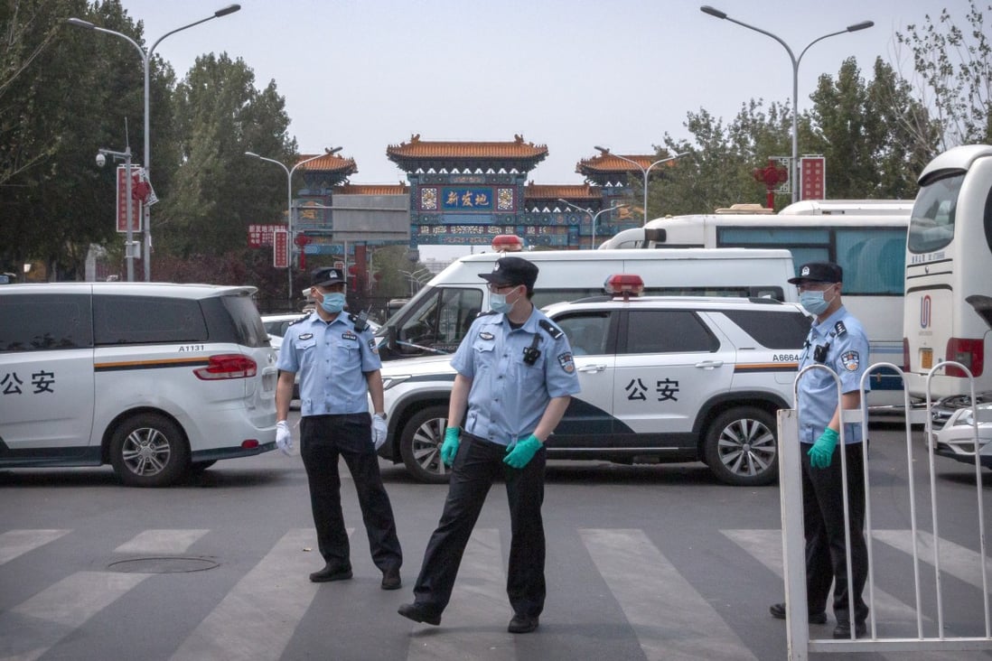Police stand guard outside an entrance to the Xinfadi wholesale market district in Beijing on Saturday. Photo: AP