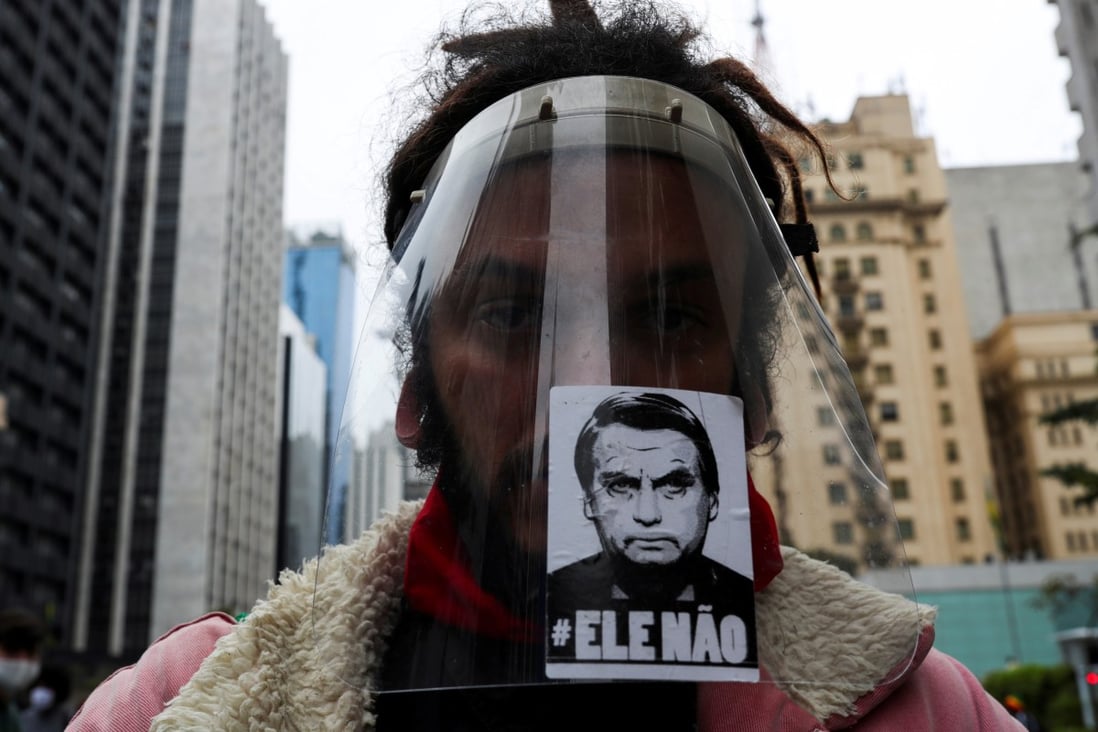 A man wears a protective face shield with a sticker of the image of Brazil’s President Jair Bolsonaro reading “not him” during a protest against racism and fascism in Sao Paulo. Photo: Reuters