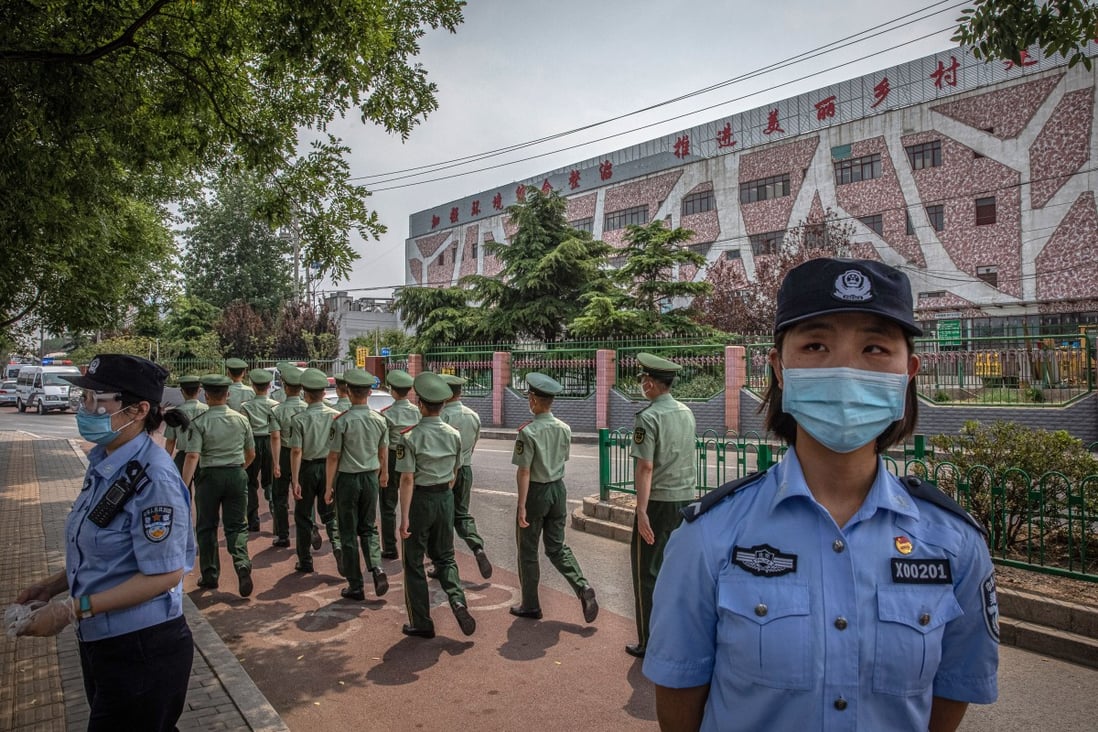 Chinese police stand guard at the Xinfadi market building in Beijing, on June 13, where a cluster of infections led to a partial shutdown of the Chinese capital city. Photo: EPA-EFE