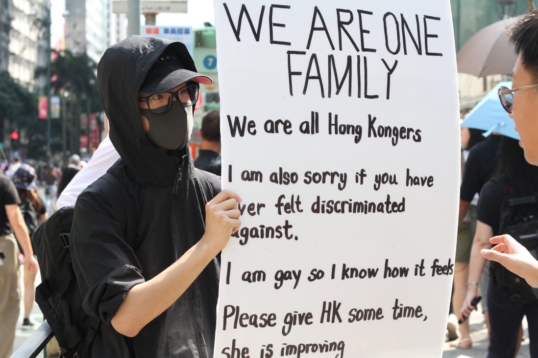 A protester stands in front of Hong Kong’s largest mosque, Kowloon Mosque, and holds a banner to show support for members of ethnic minority communities on October 20, 2019. Photo: Raquel Carvalho