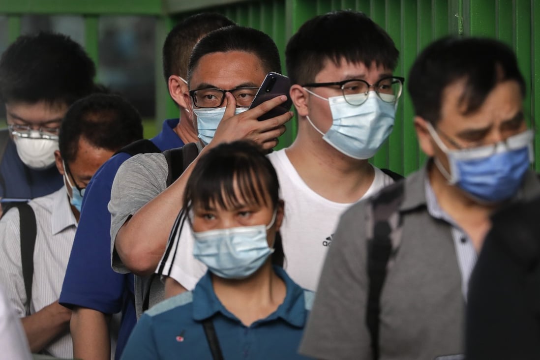 Commuters wearing protective face masks to help curb the spread of the new coronavirus line up to board a bus at a bus terminal in Beijing on June 22, 2020. Beijing acted swiftly when the virus broke out again recently and says it is under control.