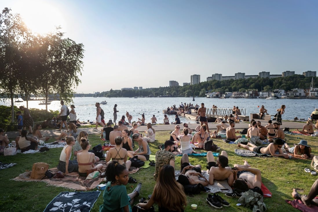 People sunbathe in a park on Lake Malar in Stockholm on June 24. Sweden has never banned gatherings or enforced the use of face masks during the pandemic. Photo: Reuters