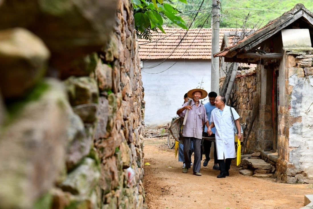 Doctor Zhang Deqing (R, front) talks to a villager while on his way to call on patients in Linyi, east China's Shandong Province. Mutual aid platforms are popular among China’s low- and middle-income households in rural areas. Photo: Xinhua