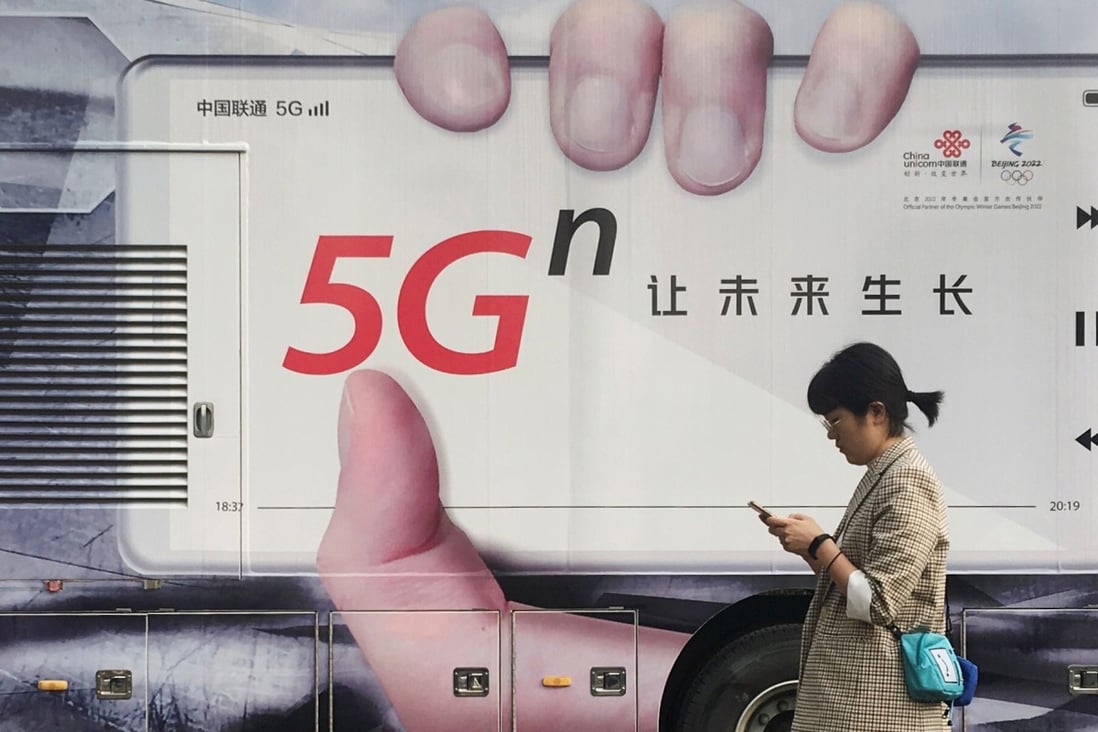 A woman using her mobile phone walks past a vehicle covered in a China Unicom 5G advertisement in Beijing, China September 17, 2019. Photo: Reuters