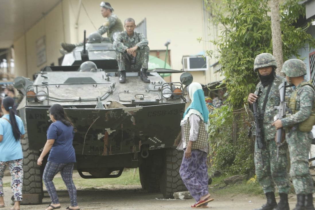 Villagers walk next to a tank in Jolo, in the Philippines, in March 2017. Photo: EPA