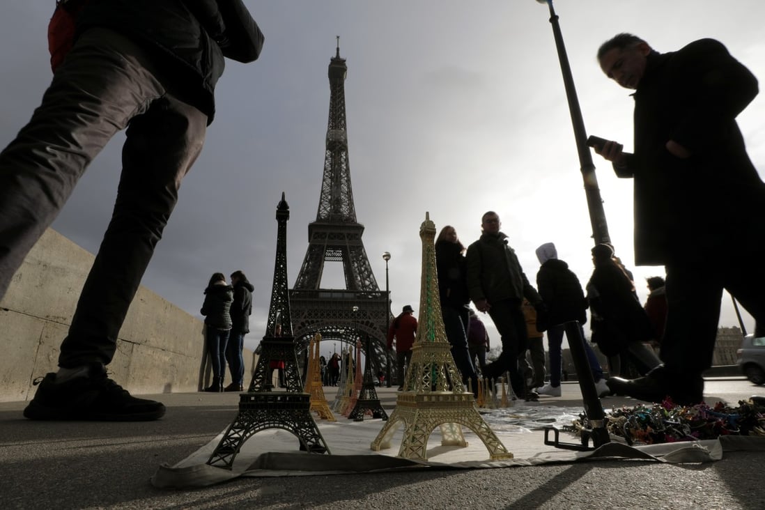 Tourists walk near the Eiffel tower in Paris. The travel and tourism industry is one of the most severely hit sectors by the Covid-19 pandemic. Photo: Reuters